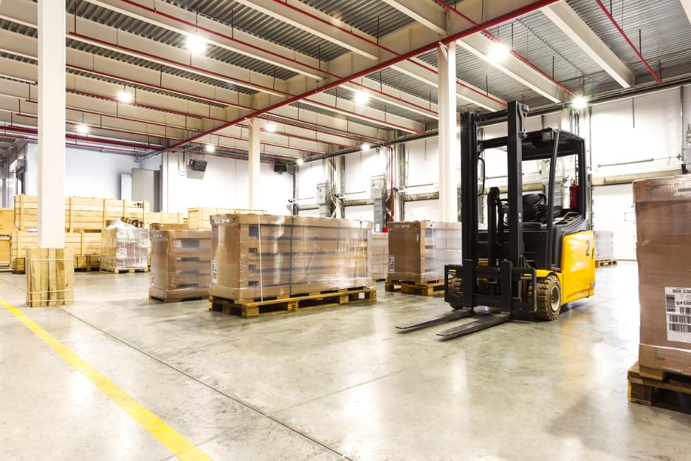 Large modern warehouse with forklifts and overhead lighting
